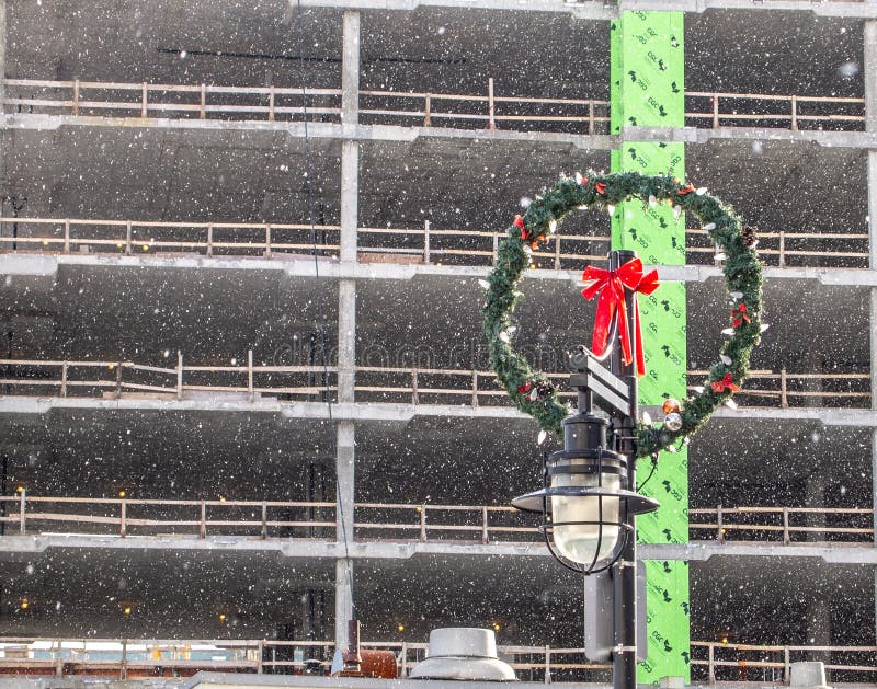 Guirnalda de la Navidad en polo ligero delante del edificio bajo construcción imágenes de archivo libres de regalías Guirnalda de la Navidad en polo ligero delante del edificio bajo construcción imágenes de archivo libres de regalías
