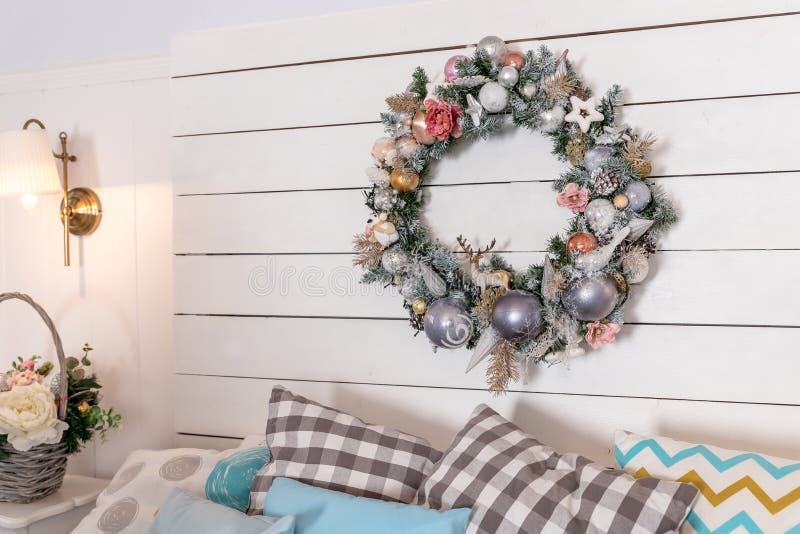 Guirnalda de las bolas de la Navidad sobre la cama Decoración del Año Nuevo en el dormitorio en rosa blando y colores azules Navi imagen de archivo Guirnalda de las bolas de la Navidad sobre la cama Decoración del Año Nuevo en el dormitorio en rosa blando y colores azules Navi imagen de archivo