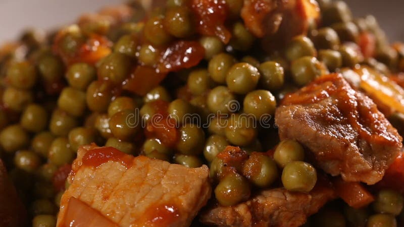 Guisado da ervilha com carne da costeleta de carne de porco e molho de tomate