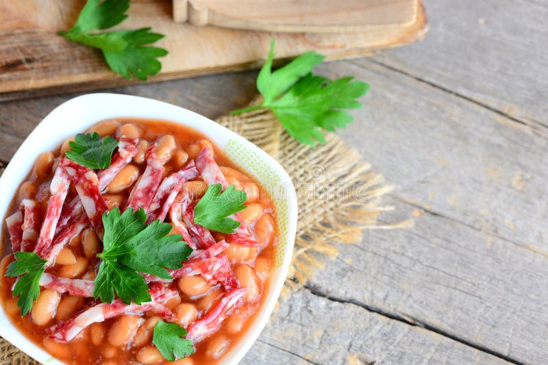 Guisado da salsicha fumado e do feijão branco Feijões brancos cozidos caseiros com salsicha fumado, molho de tomate e salsa fotografia de stock royalty free Guisado da salsicha fumado e do feijão branco Feijões brancos cozidos caseiros com salsicha fumado, molho de tomate e salsa fotografia de stock royalty free