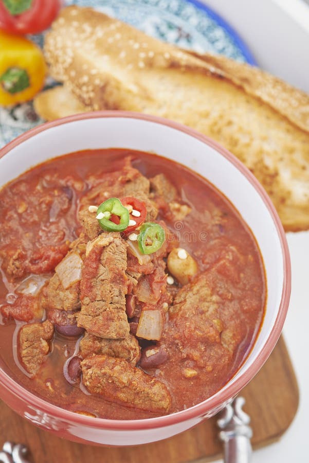 Guisado de la carne de vaca y del tomate en cuenco con pan tostado fotografía de archivo libre de regalías Guisado de la carne de vaca y del tomate en cuenco con pan tostado fotografía de archivo libre de regalías