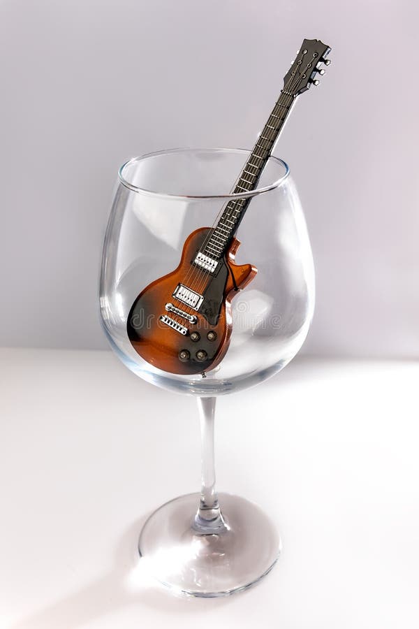 Guitar in beautiful glass wine glass on white background.