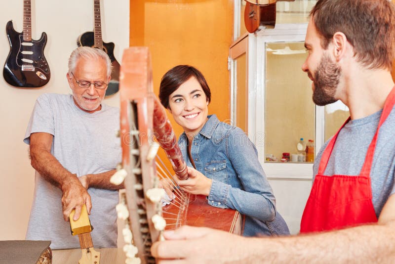 Guitar makers and apprentice working together royalty free stock image