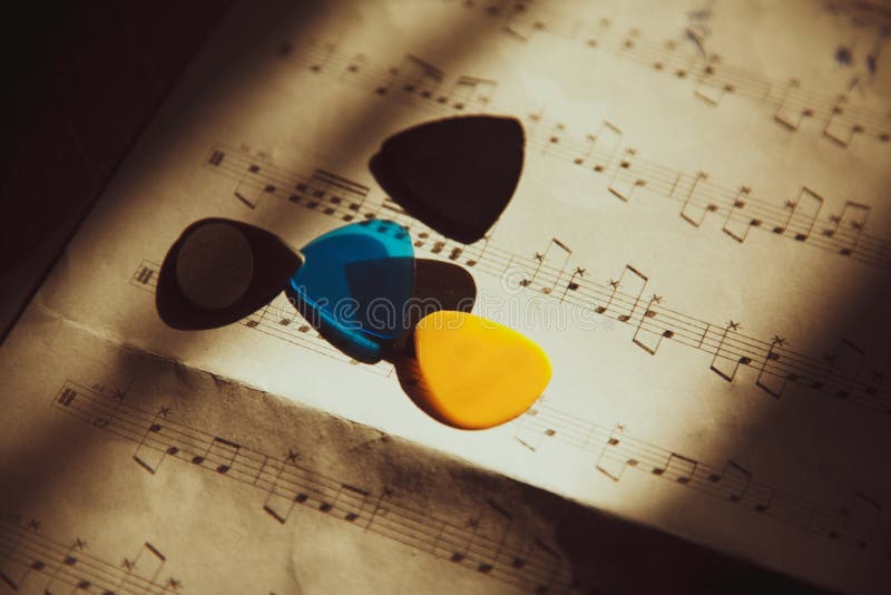Photo of the guitar picks lying on the music notes. Colorful musical notes stock images, royalty-free photos and pictures