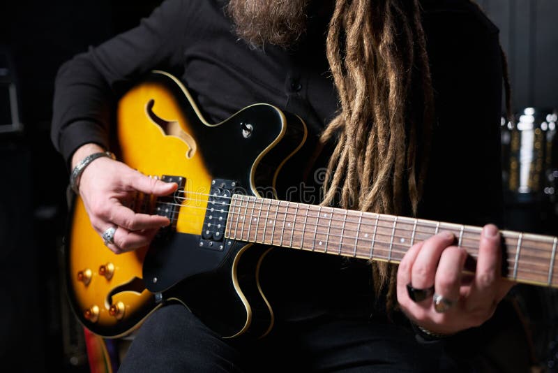 Guitarist Man Plays an Electric Guitar Closeup at Studio Stock Image