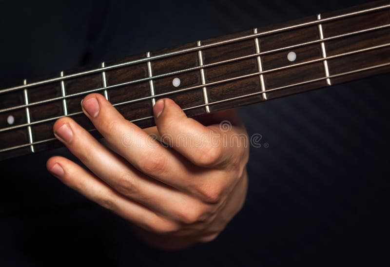 Guitariste de roche pratiquant avec la guitare basse photographie stock libre de droits Guitariste de roche pratiquant avec la guitare basse photographie stock libre de droits
