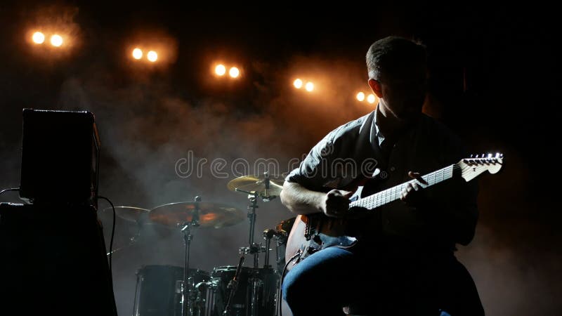 Guitariste de silhouette musicien qui joue de la guitare électrique.