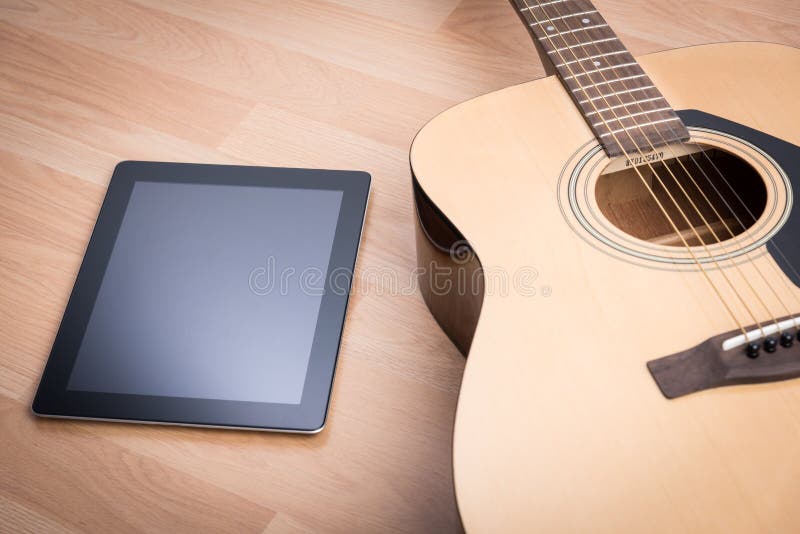 Guitarra acústica con la tableta digital fotografía de archivo libre de regalías Guitarra acústica con la tableta digital fotografía de archivo libre de regalías