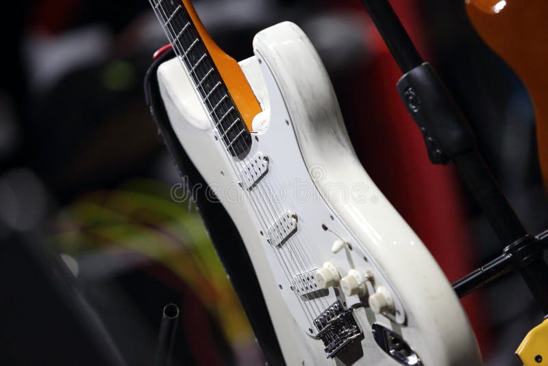 Guitarra branca de solo no suporte antes do concerto fotografia de stock royalty free Guitarra branca de solo no suporte antes do concerto fotografia de stock royalty free