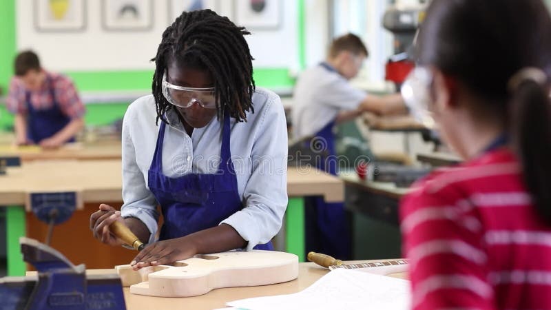 Guitarra da construção do estudante da High School na lição da carpintaria