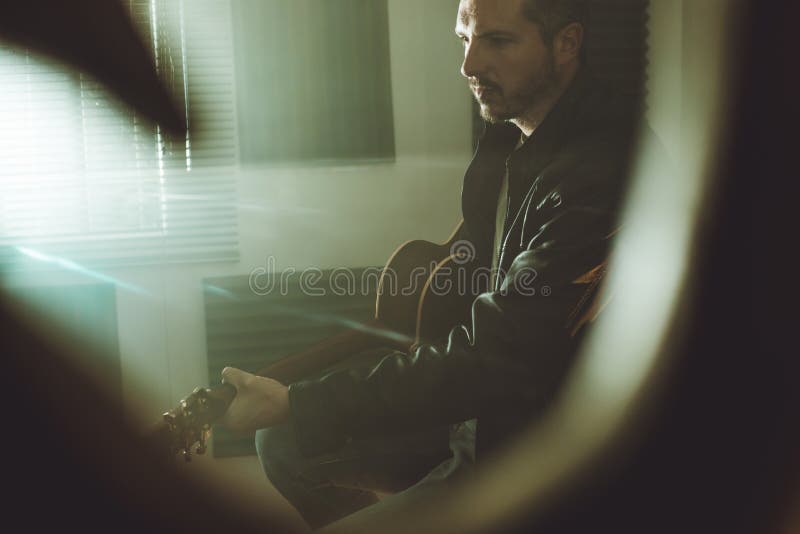 Guitarra de jogo considerável do indivíduo Músico que joga a guitarra acústica em casa fotos de stock Guitarra de jogo considerável do indivíduo Músico que joga a guitarra acústica em casa fotos de stock