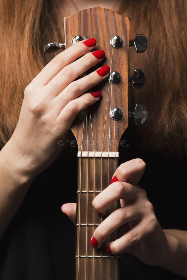 Guitarra en las manos de una mujer que toca el instrumento musical foto de archivo libre de regalías Guitarra en las manos de una mujer que toca el instrumento musical foto de archivo libre de regalías