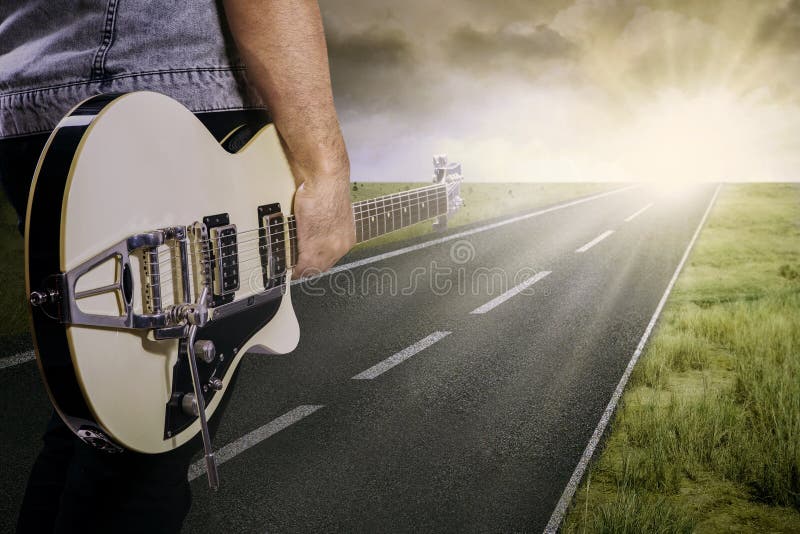 Guitarrista e sua guitarra na estrada foto de stock Guitarrista e sua guitarra na estrada foto de stock
