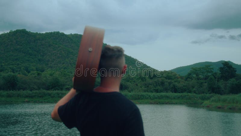 Guitarrista está olhando para o lago