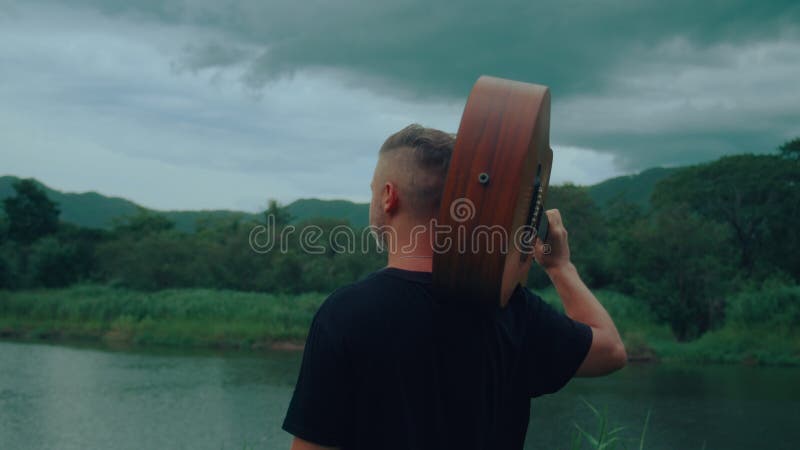 Guitarrista está olhando para o lago