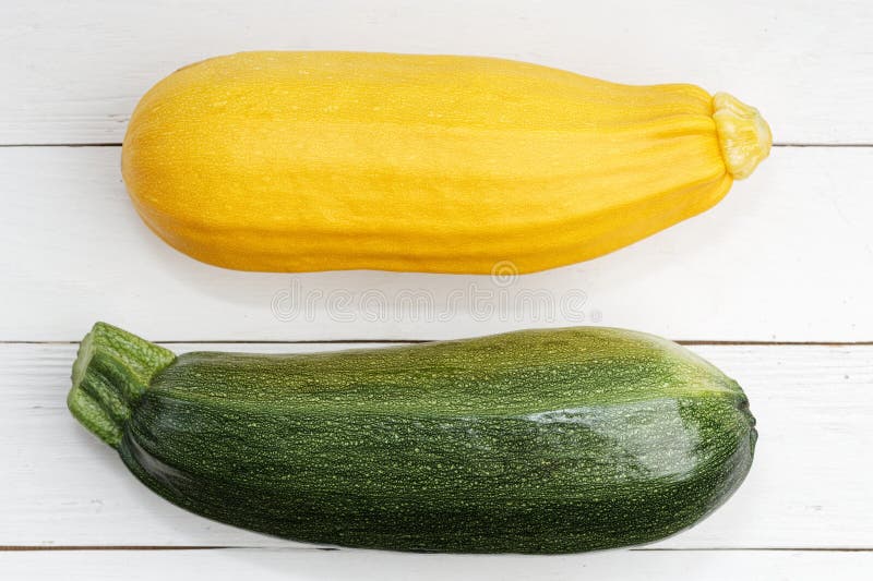 Gul för Closeup ny rå och grön zucchini på den vita trätabellen royaltyfria foton Gul för Closeup ny rå och grön zucchini på den vita trätabellen royaltyfria foton