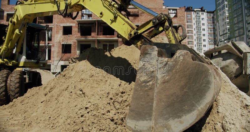 Gul grävmaskin gräver markhaken av traktorns bulldozer industriindustriarbetsindustrikonstruktion