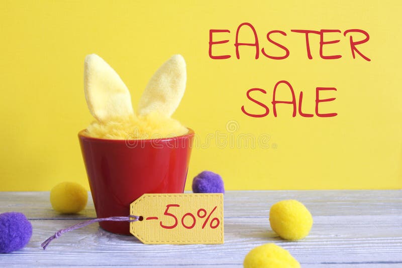 Yellow fur toy bunny in a red ceramic pot on gray wooden boards, and on a bright yellow background with the words Easter Sale, yellow paper tag with the words `-50%` and yellow and purple wool balls. Yellow fur toy bunny in a red ceramic pot on gray wooden boards, and on a bright yellow background with the words Easter Sale, yellow paper tag with the words `-50%` and yellow and purple wool balls