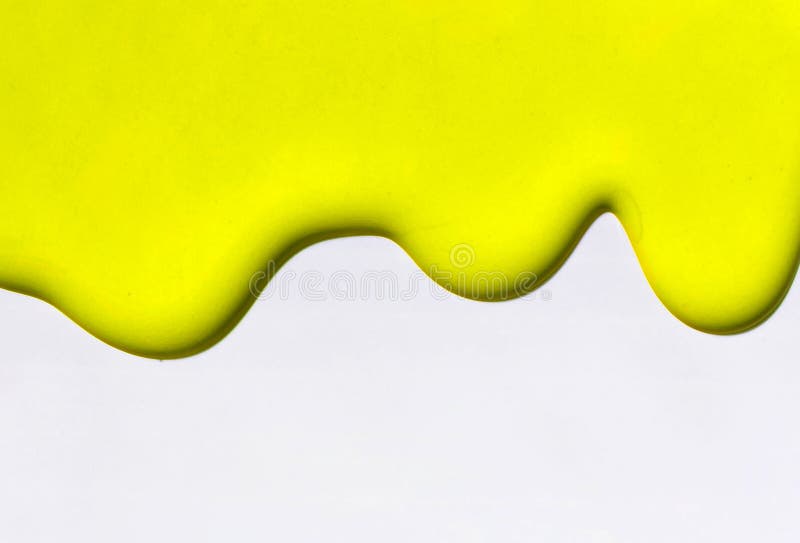 Yellow paint flows on a white background. Copy space. Yellow paint flows on a white background. Copy space.