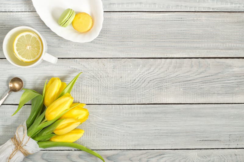 Gula tulpan, citronte och macarons på den vita trätabellen arkivbilder Gula tulpan, citronte och macarons på den vita trätabellen arkivbilder