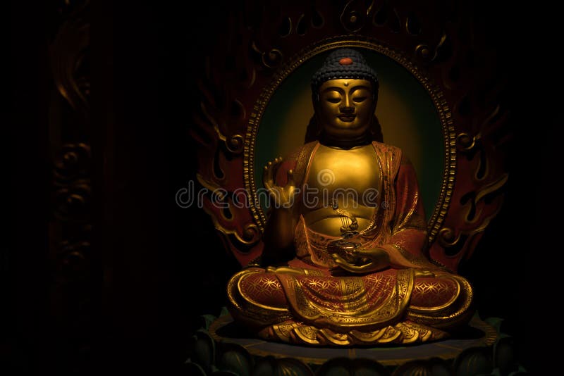 Guld- Buddhaskulptur på en mörk bakgrund fotografering för bildbyråer Guld- Buddhaskulptur på en mörk bakgrund fotografering för bildbyråer