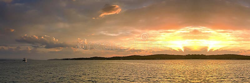 Guld- havösolnedgång till och med molnet och med vattenreflexioner och ett fartyg royaltyfri foto Guld- havösolnedgång till och med molnet och med vattenreflexioner och ett fartyg royaltyfri foto