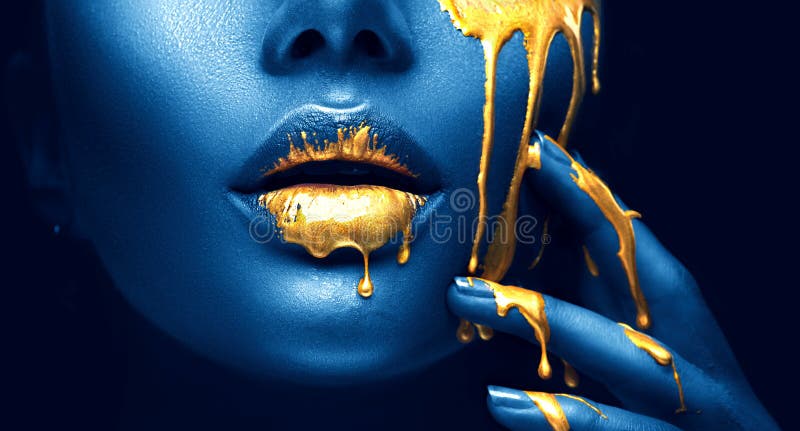 Guld- målarfärg smetar droppander från framsidakanterna och handen, guld- vätskedroppar på härlig modellflickmun, idérik makeup arkivfoton