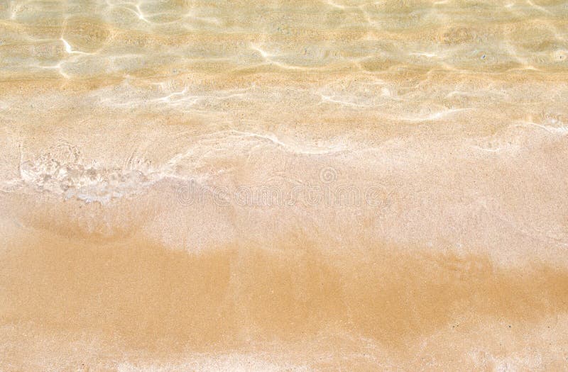 Guld- sand och genomskinligt vatten, textur royaltyfri bild