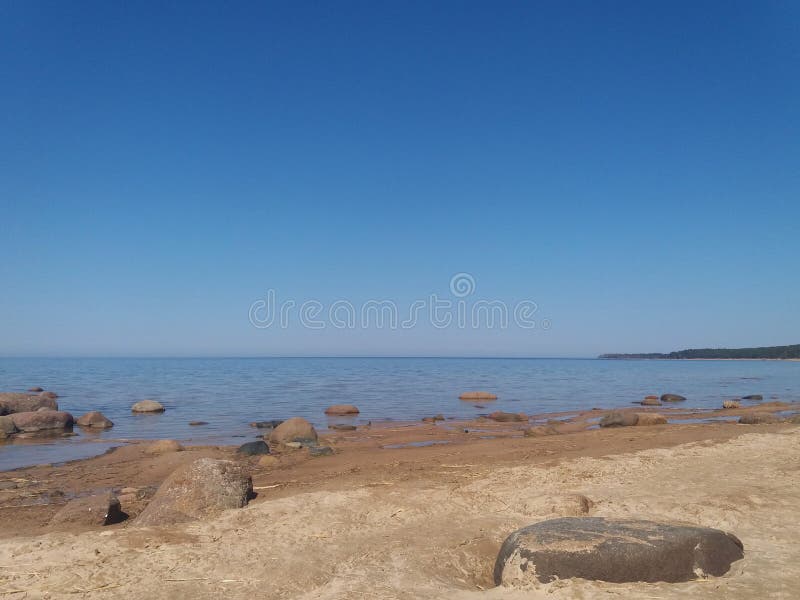 Gulf of Finland, cold northern Baltic Sea, Finland. The beauty of the northern summer. Sea, beach, large stones, horizon. Calm