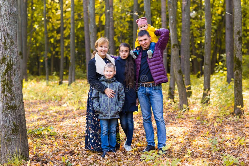 Gullig familj i en parkera på en höst arkivfoto Gullig familj i en parkera på en höst arkivfoto