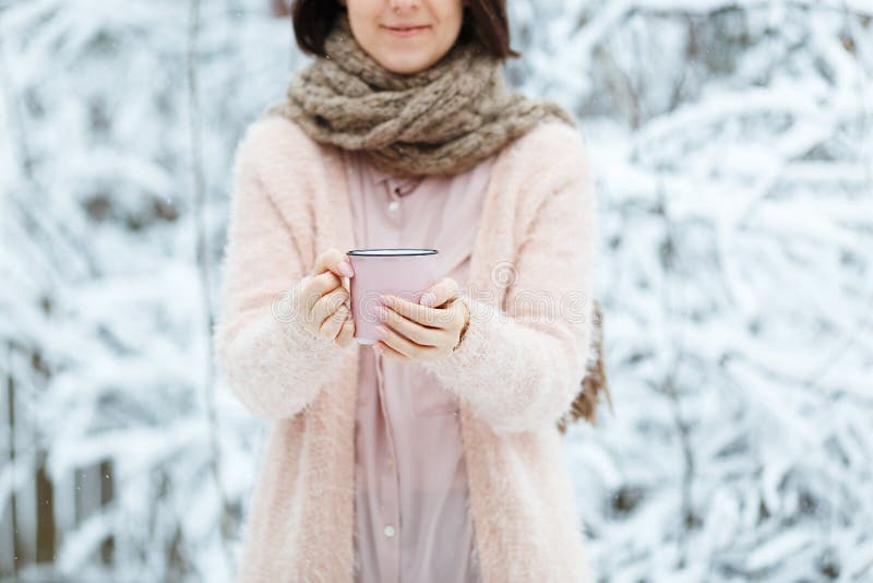 Gullig flicka med en rosa kopp kaffe i vinterskogen arkivfoton