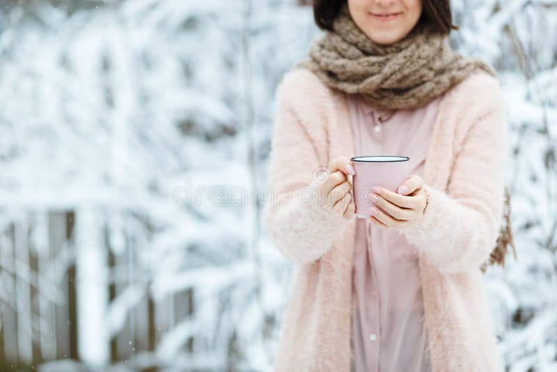 Gullig flicka med en rosa kopp kaffe i vinterskogen fotografering för bildbyråer