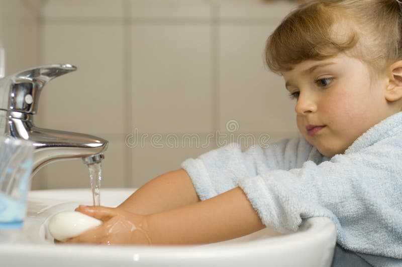 Söt flicka tvättar händerna arkivbild