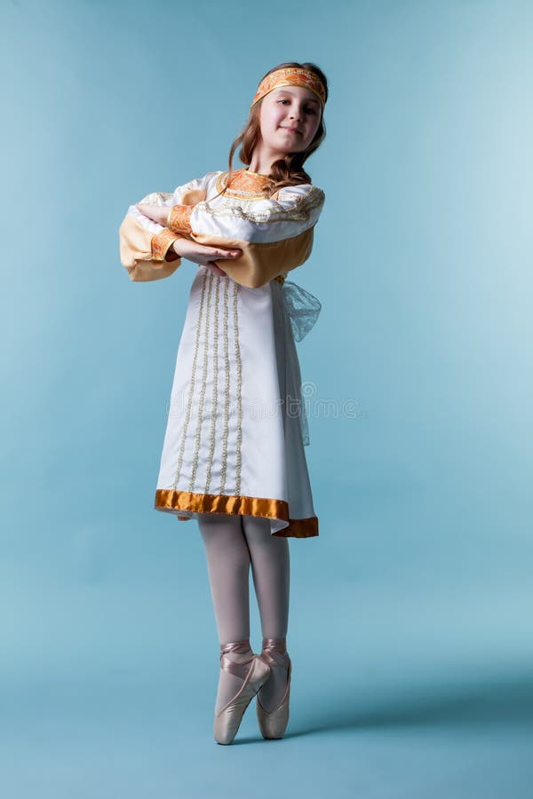 Gullig liten ballerina som poserar i folkklänning royaltyfri bild Gullig liten ballerina som poserar i folkklänning royaltyfri bild