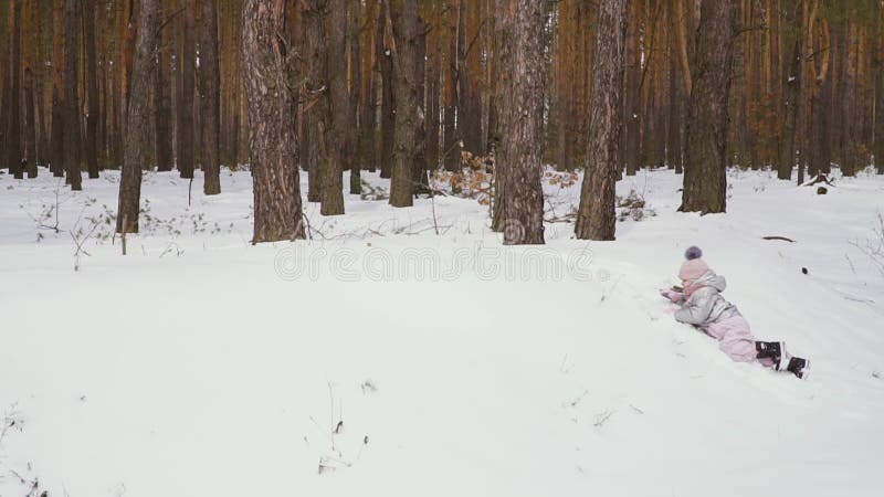 Gullig liten flicka i snöskogen som är slowmotion