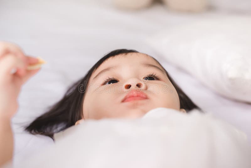 Gullig liten flicka som hemma äter kakan royaltyfria bilder Gullig liten flicka som hemma äter kakan royaltyfria bilder