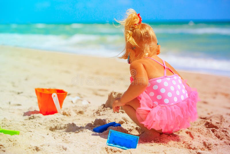 Gullig liten flickalek med sand på stranden arkivbilder Gullig liten flickalek med sand på stranden arkivbilder