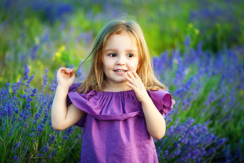 Gullig liten le flicka i lavendelfält Liten blond barnflicka begrepp av moderskap, skydd av barn royaltyfri fotografi Gullig liten le flicka i lavendelfält Liten blond barnflicka begrepp av moderskap, skydd av barn royaltyfri fotografi