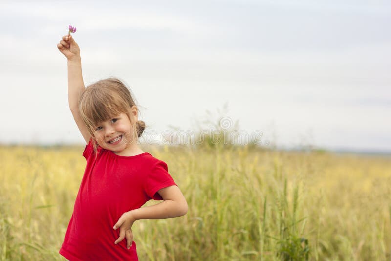 Gullig liten le flicka som rymmer den lilla blomman upp i hand royaltyfri foto Gullig liten le flicka som rymmer den lilla blomman upp i hand royaltyfri foto