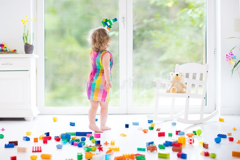 Gullig skratta litet barnflicka som spelar med färgrika kvarter royaltyfri bild