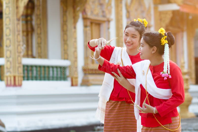 Gulliga flickor i thailändsk traditionsdräkt