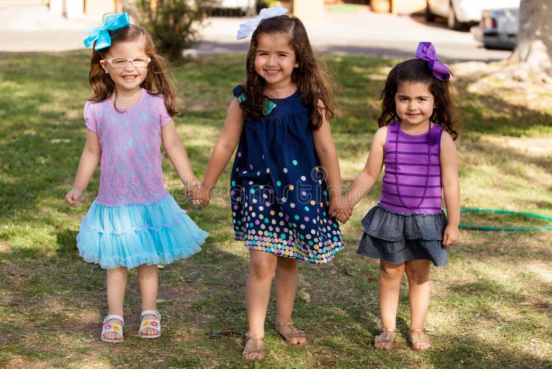 Full length portrait of a group of little friends holding hands in a park. Full length portrait of a group of little friends holding hands in a park