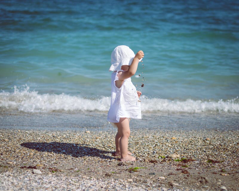 Gulligt behandla som ett barn litet barnflickan på stranden Sommarsolnedgång på stranden arkivfoton Gulligt behandla som ett barn litet barnflickan på stranden Sommarsolnedgång på stranden arkivfoton
