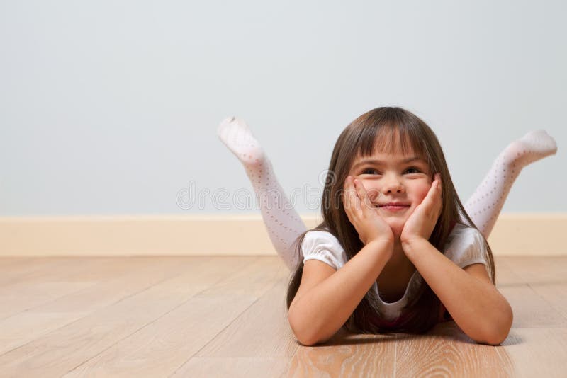 Söt flicka ligger på golvet arkivbilder
