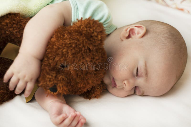 Gulligt lite att behandla som ett barn att sova i en söt sömn som kramar en björn fotografering för bildbyråer Gulligt lite att behandla som ett barn att sova i en söt sömn som kramar en björn fotografering för bildbyråer
