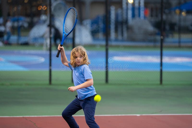 Gullunge spela tennis. Unga barn slog tennis ball med tennis racket. aktiv träning för barn. Sommaraktiviteter för arkivfoto