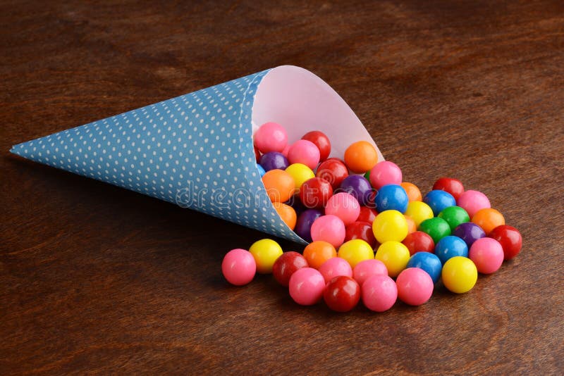 Gumballs coloridos da bolha em um cone de papel azul foto de stock royalty free Gumballs coloridos da bolha em um cone de papel azul foto de stock royalty free