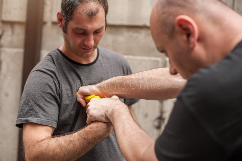 Gun Disarm. Self Defense Techniques Against A Gun Point. Stock Photo
