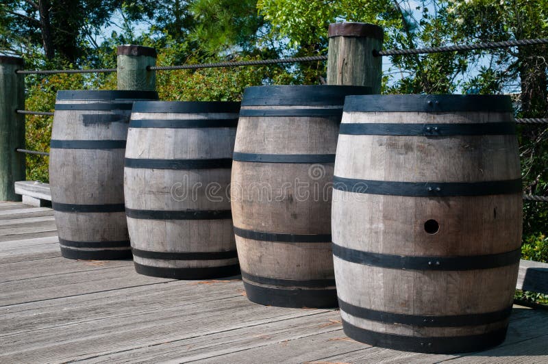 Four wooden barrels along a wooden deck. Barrels have black metal straps around them. They are similar to whiskey barrels, but are used for gun powder. Metal steel drum stock images, royalty-free photos and pictures