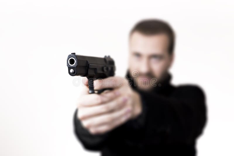 Blonde man with facial hair, aiming with a gun.